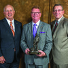 Craig Redmon, center, receives his Legislative Leadership Award from Vice President David Klindt, left, and CEO Barry Hart.