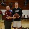Coy Smith is presented a basketball by Coach Anderson in honor of scoring 1000 points in his career as a Canton Tiger.